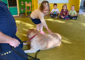 Dziewczynka głaszcze psa
