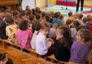Dzieci słuchają koncertu, artysta gra na saksofonie
