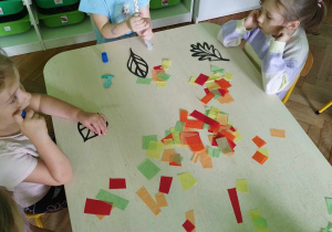 Dzieci tworzą witraże z kolorowej bibuły