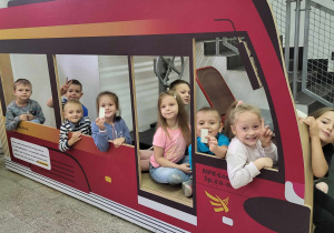 dzieci siedzą w czerwonym wagonie