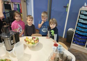 Dzieci czekają na swoją kolej żeby wrzucić owoce do sokowirówki.
