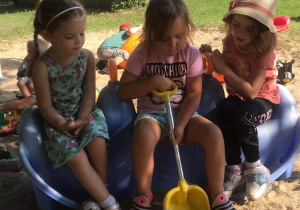 Trzy dziewczynki siedzą na bijącej zabawce