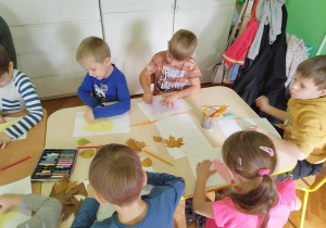 Dzieci tworzą pracę plastyczną techniką frotażu