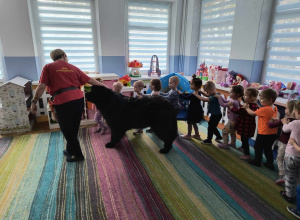 Dzieci bawią się z psim terapeutą.