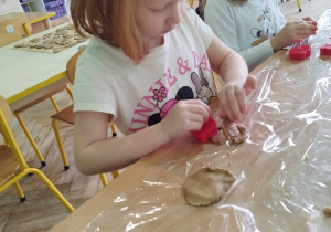 Dziewczynka odciska forenką kształt piernika