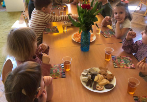 Dzieci siedzą przy stoliku - wspólnie świętują dzień kobiet