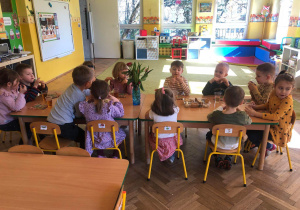 Grupa dzieci siedzi przy stoliku