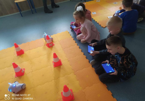 Dzieci biorą udział w zajęciach z robotyki i pracują długopisami 3d