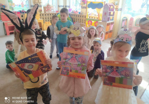Dzieci w Wielkanocnych przebraniach wykonują różne zadania związane z tym świętem.