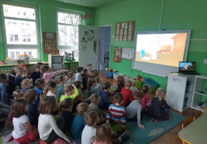 dzieci oglądają na tablicy interaktywnej film edukacyjny