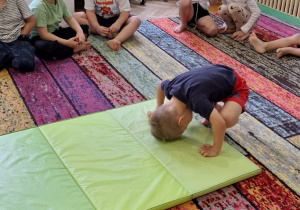 Dzieci ćwiczą na dywanie, materacu i równoważni