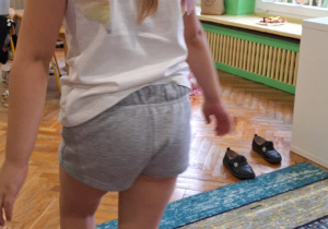 Dzieci ćwiczą na dywanie, materacu i równoważni
