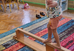 Dzieci ćwiczą na dywanie, materacu i równoważni
