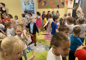 Na zdjęciu widać jak dzieci bawią się podczas przedszkolnej uroczystości