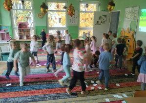 Dzieci bawią się na dywanie na grupowych urodzinach