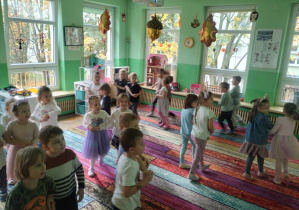 Dzieci bawią się na dywanie na grupowych urodzinach