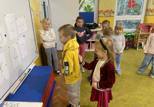 Chłopiec odgaduje co koleżanka rysuje na jego plecach