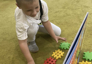 Chłopiec odwzorowuje układ klocków