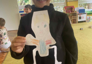 Chłopiec pokazuje swoją pracę