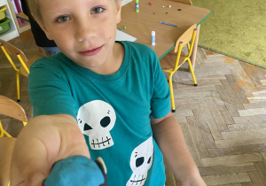 Chłopiec pokazuje co ulepił z plasteliny