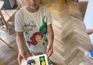 dziewczynka prezentuje swoją pracę