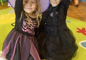 dwie dziewczynki trzymając się za rączki pozują do zdjecia