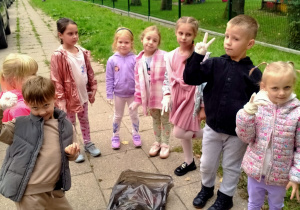 Dzieci sprzątają okolice przedszkola.