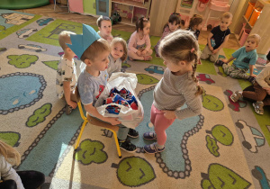 Dziewczynka składa życzenia Frankowi. Franek siedzi w koronie na głowie i daje prezent dziewczynce.