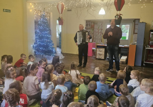 Dzieci słuchają gry na akordeonie