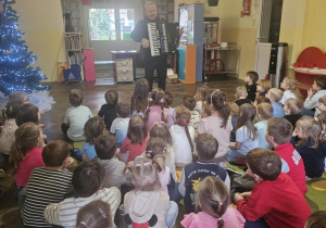 Dzieci słuchają gry na akordeonie