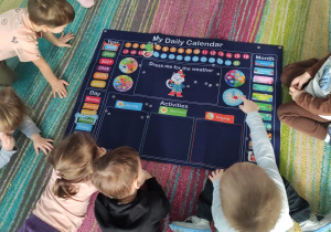 dzieci wykonują na dywanie zadanie z języka angielskiego