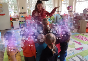 dzieci wykonują na dywanie zadanie z języka angielskiego