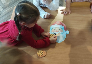 Dzieci karmią Świętego Mikołaja ciasteczkami