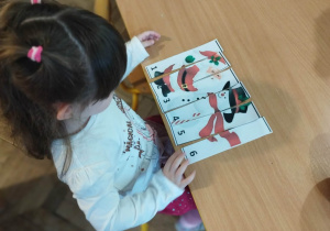 Dziewczynka układa puzzle