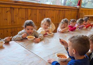 Dzieci biorą udział w warsztatach świątecznych. Robią stroiki i dekorują domki z piernika