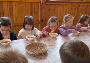 Dzieci biorą udział w warsztatach świątecznych. Robią stroiki i dekorują domki z piernika