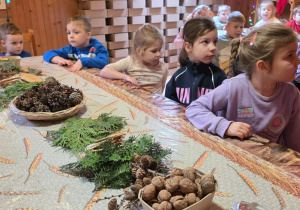 Dzieci biorą udział w warsztatach świątecznych. Robią stroiki i dekorują domki z piernika