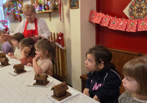 Dzieci biorą udział w warsztatach świątecznych. Robią stroiki i dekorują domki z piernika