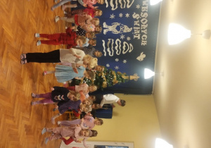 Dzieci siedzą na dywanie i oglądają pokaz tańców z bajek