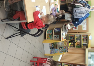 Dzieci biorą udział w zajęciach w bibliotece