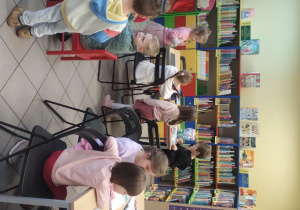 Dzieci biorą udział w zajęciach w bibliotece