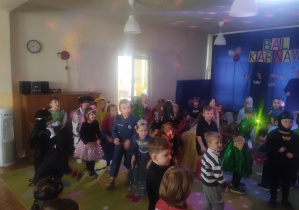 Dzieci w przebraniach bawią się na balu karnawałowym w przedszkolu