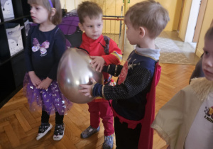 Dzieci w przebraniach bawią się na balu karnawałowym w przedszkolu