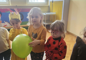 Dzieci w przebraniach bawią się na balu karnawałowym w przedszkolu