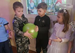 Dzieci w przebraniach bawią się na balu karnawałowym w przedszkolu