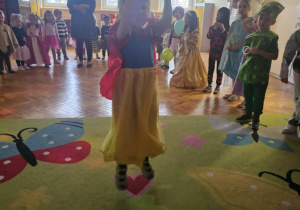 Dzieci w przebraniach bawią się na balu karnawałowym w przedszkolu