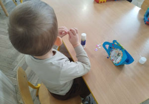 Chłopiec ozdabia kubeczek serduszkami