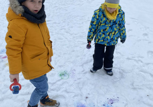 Dzieci podziwiają kolorowy śnieg