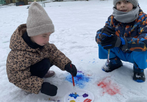 Dzieci barwią śnieg farbami
