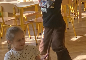 Dziewczynka gra rytm a chłopiec tańczy